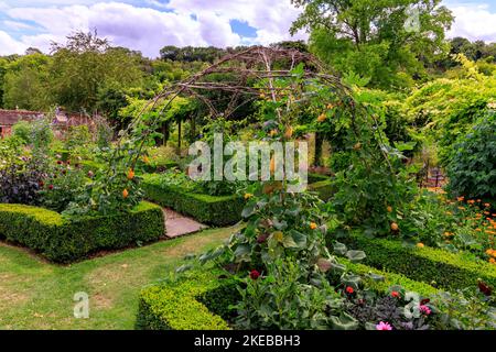 Farbenfrohe Pflanzen und Pflanzen im ummauerten Garten des Heale House - einem aus Backsteinen gebauten Herrenhaus aus dem 17.. Jahrhundert in Middle Woodford, Wiltshire, England, Großbritannien Stockfoto