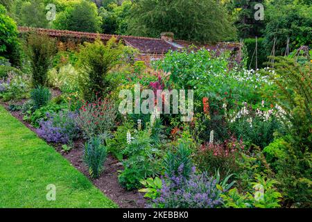 Farbenfrohe Pflanzen und Pflanzen im ummauerten Garten des Heale House - einem aus Backsteinen gebauten Herrenhaus aus dem 17.. Jahrhundert in Middle Woodford, Wiltshire, England, Großbritannien Stockfoto