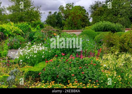 Farbenfrohe Pflanzen und Pflanzen im ummauerten Garten des Heale House - einem aus Backsteinen gebauten Herrenhaus aus dem 17.. Jahrhundert in Middle Woodford, Wiltshire, England, Großbritannien Stockfoto