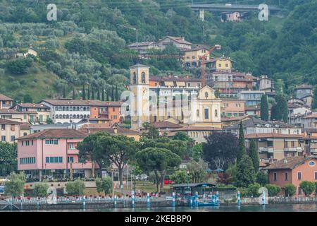 Sulzano, Italien - 05-06-2022: Panorama des Seeufers von Sulzano mit farbigen Häusern, die sich im See Iseo spiegeln Stockfoto