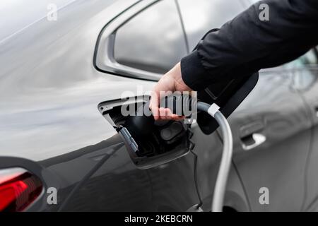 Nahaufnahme des Elektrofahrzeugsteckers LadestOP - modernes EV-Ladekabel mit man-Kabel im Auto - selektiver Fokus Fahrzeugbild Stockfoto