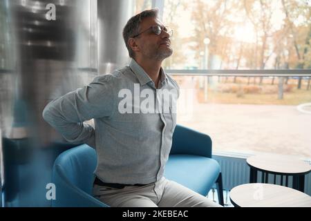 Der gutaussehende Mann befindet sich im Erholungsbereich des Bürozentrums Stockfoto