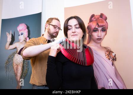 Birmingham, Großbritannien. 11.. November 2022. Die Kunstverwalterin Simona Matuozzo probiert ein Halsstück namens Pagoda II des Künstlers Dauvit Alexander. Die Arbeit ist Teil einer Ausstellung "Queer Metals" im Midlands Arts Centre, Birmingham, vom 12.. Bis 19. November. Die 8 Künstler der Schau beschäftigen sich mit der Metallverarbeitung und der Vielfältigkeit von Queerness. Kredit: Peter Lopeman/Alamy Live Nachrichten Stockfoto