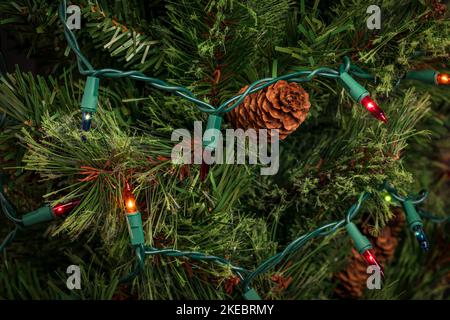 Weihnachtsschnur Lichter mit schlechten Glühbirne auf Weihnachtsbaum. Feiertagsbeleuchtung Reparatur, Sicherheit und Dekoration Konzept. Stockfoto