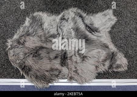 Weicher Teppich aus Lammleder in Kunstsilber auf dem Schlafzimmerboden Stockfoto