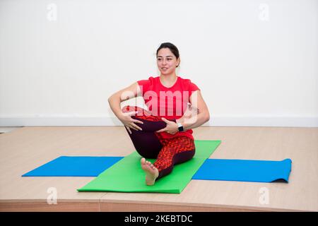 BAKU, ASERBAIDSCHAN, 10. MÄRZ 2018 : Junge attraktive Frau macht zu Hause Yoga-Übungen Stockfoto