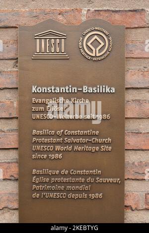 Große Nahaufnahme der Metall-UNESCO-Weltkulturerbe-Plakette, die an der roten Backsteinmauer der berühmten Basilika Konstantin in Trier angebracht ist,... Stockfoto