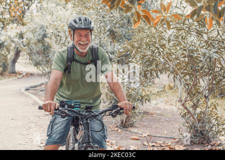 Ein alter reifer Mann, der Fahrrad fährt und die Natur im Freien genießt und Spaß hat. Senior mit einem gesunden und gesunden Lebensstil. Stockfoto