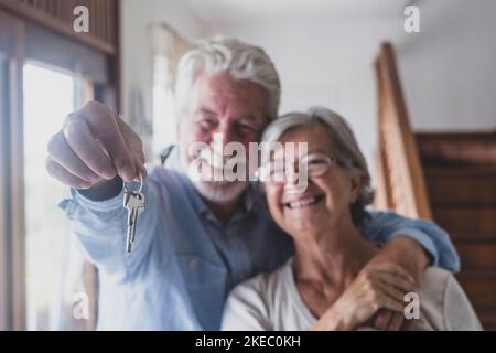 Glückliche ältere alte alte Frau und Mann Kunde Vermieter halten Schlüssel zu neuen Haus Wohnung geben, um Kamera, ältere Rentner Paar von Senioren Hand Immobilienbesitzer machen Verkauf Kauf Immobilie Deal Konzept, Nahaufnahme zu sehen Stockfoto