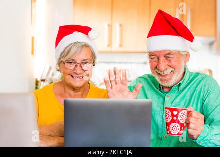 Zwei Senioren rufen ihre Familie zu Hause an und feiern weihnachten mit einem Laptop Stockfoto