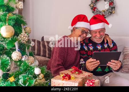 Zwei Senioren rufen ihre Familie zu Hause an und feiern weihnachten mit einem Laptop Stockfoto