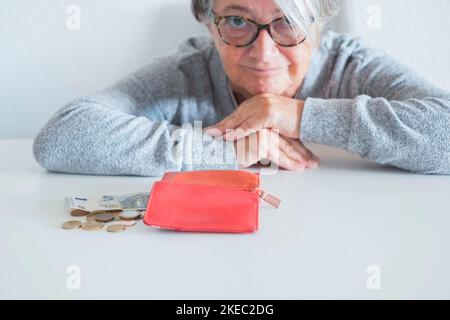 Nahaufnahme von Senior Zählen ihr Einkommen und wie manny Momey hat sie - Brieftasche ohne Geld auf der Geschichte Und eine reife Frau, die die Kamera anschaut Stockfoto