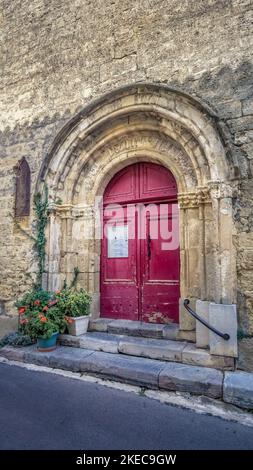 Eingangstor der Kirche Notre Dame in Moussan. Im Portalbogen sind noch Reste der Losung 'Liberté, Égalité, Fraternité' zu sehen, die in der Zeit der Französischen Revolution geschnitzt wurde. Stockfoto