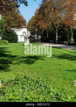 Park an der Herzog-Wilhelm-Straße, nahe Sendlinger Tor, mit Geschäften, Restaurants, Spielplatz, Darunter fließt der ehemalige Stadtgrabenbach, der wieder an die Oberfläche gebracht werden soll. Stockfoto