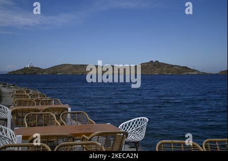 Seascape mit szenischem Blick auf ein traditionelles griechisches Café Rattan Möbel an der Küste von Vourkari in Kea Insel, Kykladen Griechenland. Stockfoto