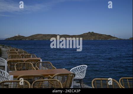 Seascape mit szenischem Blick auf ein traditionelles griechisches Café Rattan Möbel an der Küste von Vourkari in Kea Insel, Kykladen Griechenland. Stockfoto