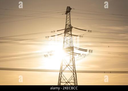 Grelles Sonnenlicht scheint über einem Strommast. Stockfoto