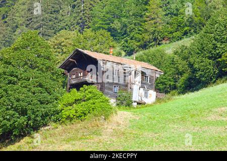 Berghof am steilen Berghang in den Bergwiesen im Südtiroler Ultental Stockfoto