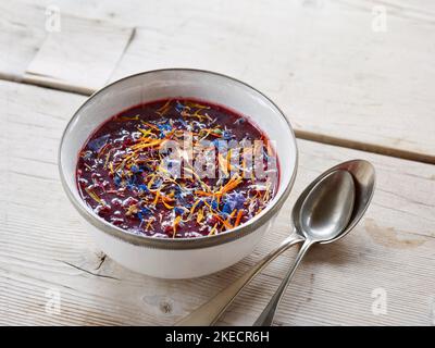ayurvedische Küche, Chutney mit dunklen Früchten in einer hellen Schale auf einem hellen Holztisch Stockfoto