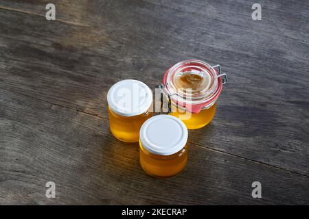 ayurvedische Ernährung, Schritte zur Zubereitung von hausgemachtem Ghee aus Butter - gefilterter, noch flüssiger Ghee in drei Vorratsgläsern. Stockfoto