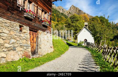 Altes Bauernhaus und Kapelle am sonnigen Herbsttag in den Bergen. Bergdorf Gerstruben bei Oberstdorf vor Höfats. Allgäuer Alpen, Bayern, Deutschland, Europa Stockfoto