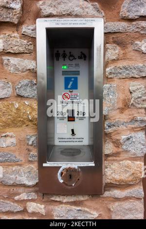 Elektronische Toilette Zahlstelle an einer öffentlichen Toilettenwand in viel Wenlock, Shropshire, England. Stockfoto