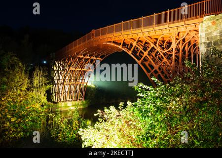 Nachtansicht der Eisernen Brücke über den Fluss Severn, beleuchtet von Lichtern. Shropshire, England. Stockfoto