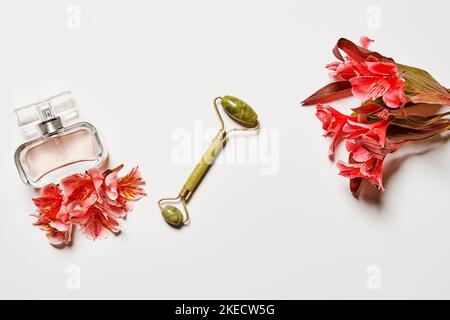 Blumen und Parfümflaschen auf einer weißen Oberfläche mit Platz für Text, der über das, was du retest, beschriftet werden kann Stockfoto