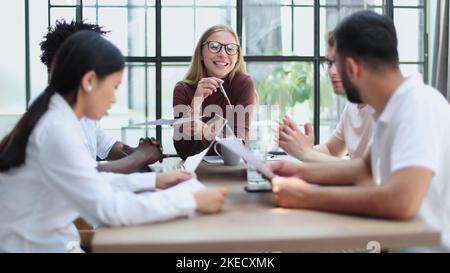 Eine Gruppe von verschiedenen Geschäftsleuten, die an einem Tisch sitzen Stockfoto