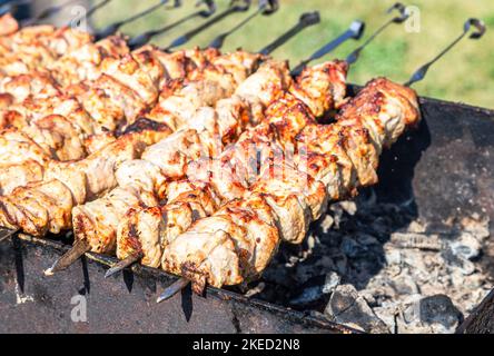 Kochen Sie traditionelle appetitliche heiße Schischebab oder Schaschlik auf Metallspießen Stockfoto