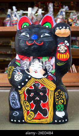 Eine schwarze Manekineko-Statue im Bikan-Distrikt Kurashiki, Präfektur Okayama, Japan. Stockfoto