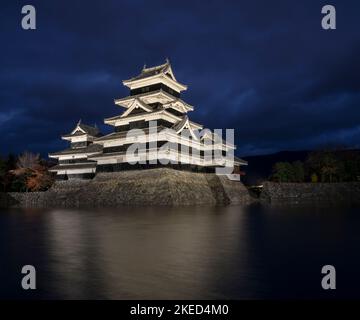 Schloss Matzumoto, ein nationaler Schatz in Matzumoto, Präfektur Nagano, Japan, bei Dämmerung beleuchtet. Stockfoto