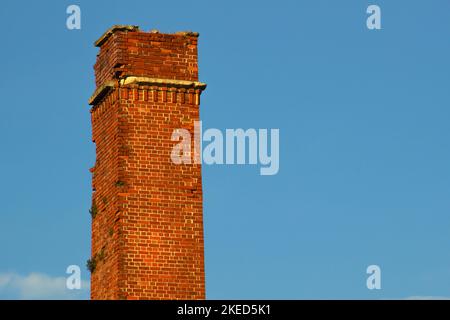 Ein alter Steinkamin, isoliert am Himmel Stockfoto