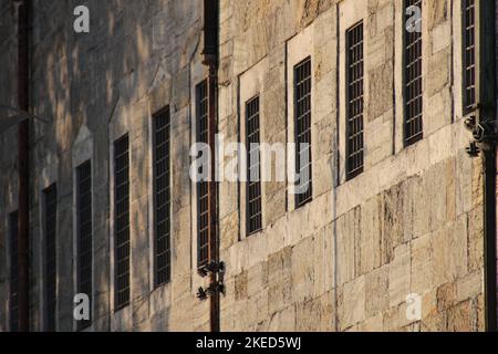 Außenansicht des historischen osmanischen Gebäudes und der Fenster mit Eisenstangen. Selektiver Fokus auf Fenster und Wand schließen Stockfoto