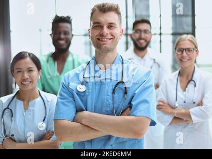 Multinationale Praktikanten und Professor kooperieren bei einem Krankenhausgespräch Stockfoto