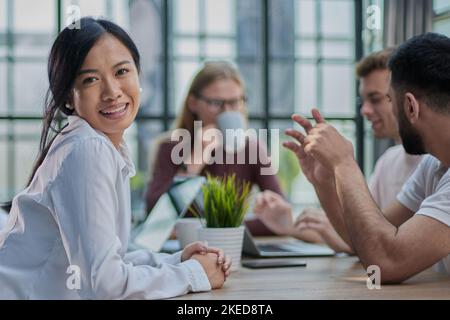 Multiethnische Geschäftspartner treffen sich mit Laptops am Tisch im modernen Büro Stockfoto