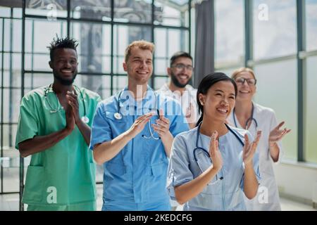 Professionelle multinationale Ärzte applaudieren vor der Kamera. Diagnosediskussion Stockfoto