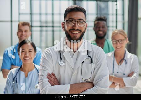 Erfolgreiche Ärzteteam sind auf Kamera und lächelnd, während im Krankenhaus ständigen Stockfoto