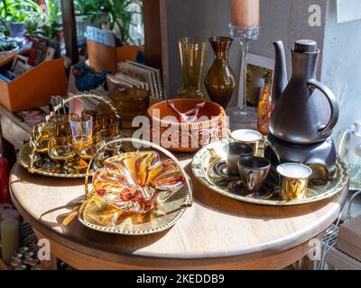 Vintage braune Glaswaren auf Metallgeräten. Holztisch. Sonnenlicht. Stockfoto