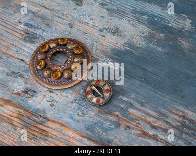 Nahaufnahme von zwei Broschen auf Holz. Nationale Dekoration der Balen - Sakta Stockfoto