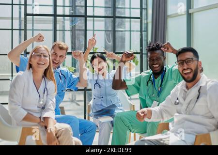 Glückliches Team von verschiedenen Ärzten in der Krankenhauslobby. Stockfoto