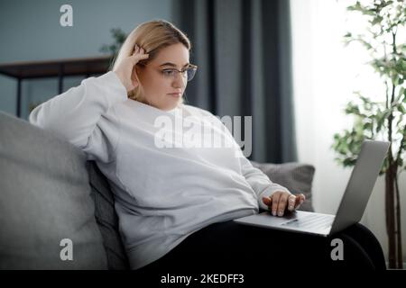 Fokussierte Frau mit Laptop Stockfoto