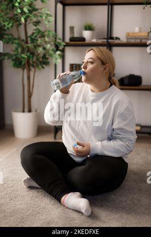 Frau Trinkwasser nach dem training Stockfoto