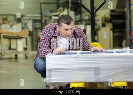 Reifer Mann, der die Lieferung im Geschäft überprüft Stockfoto