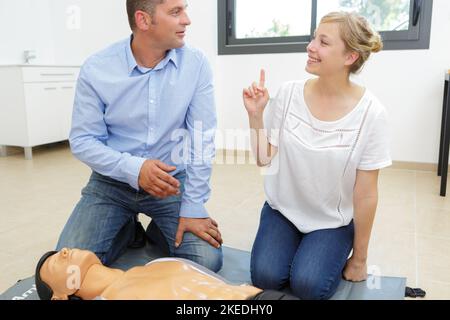 Frau demonstriert hlw an Schaufensterpuppe in der erste-Hilfe-Klasse Stockfoto