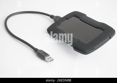 Tragbare externe Festplatte mit angeschlossenem USB-Kabel, weißer Hintergrund Stockfoto