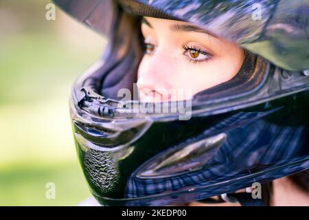 Nahaufnahme der Augen von Teenage Female Adjusting Dirt Bike Helm | Motorrad Stockfoto