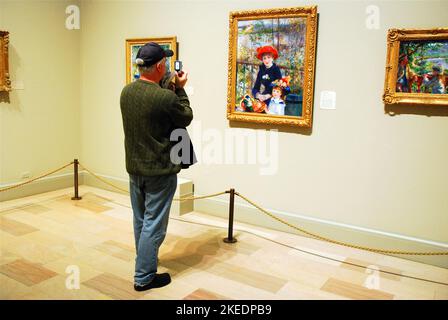 Ein erwachsener Mann fotografiert zwei Schwestern auf der Terrasse, ein Gemälde von Pierre-Auguste Renoir, im Kunstmuseum von Chicago Stockfoto