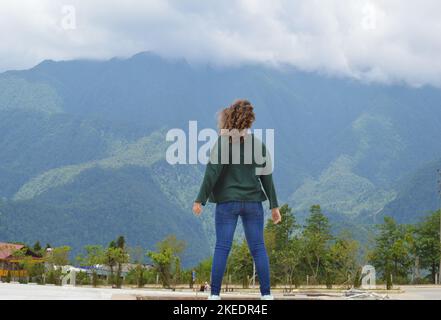 Steh auf Mädchen mit Blick auf die Sapa Massive Bergkette, Vietnam Stockfoto