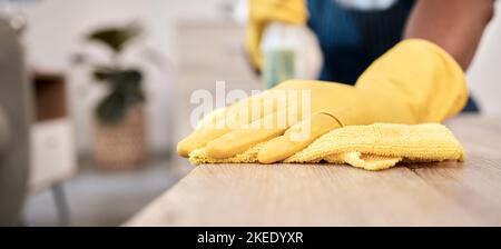 Wischen, Tuch und Hände eines Mannes auf einem Tisch, der den Staub mit Handschuhen in einem Haus reinigt. Bakterien, Service und Reiniger mit zu reinigenden Produkten Stockfoto